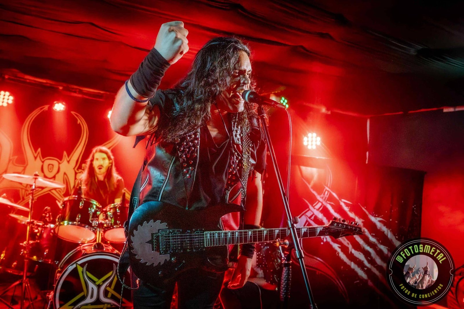 Resumen Editorial Febrero 2026: Resistencia y Densidad en la Escena Chilena 13 Baterista con chaqueta de cuero tocando batería en escenario iluminado durante concierto.