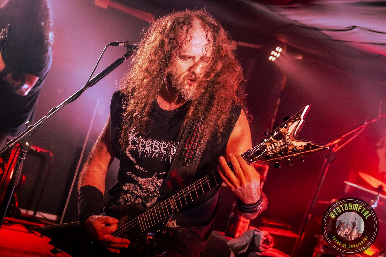 Resumen Editorial: Metal en Vivo – Marzo 2026 1 Cantante con gafas y barba en escenario iluminado de verde apuntando y sosteniendo micrófono.