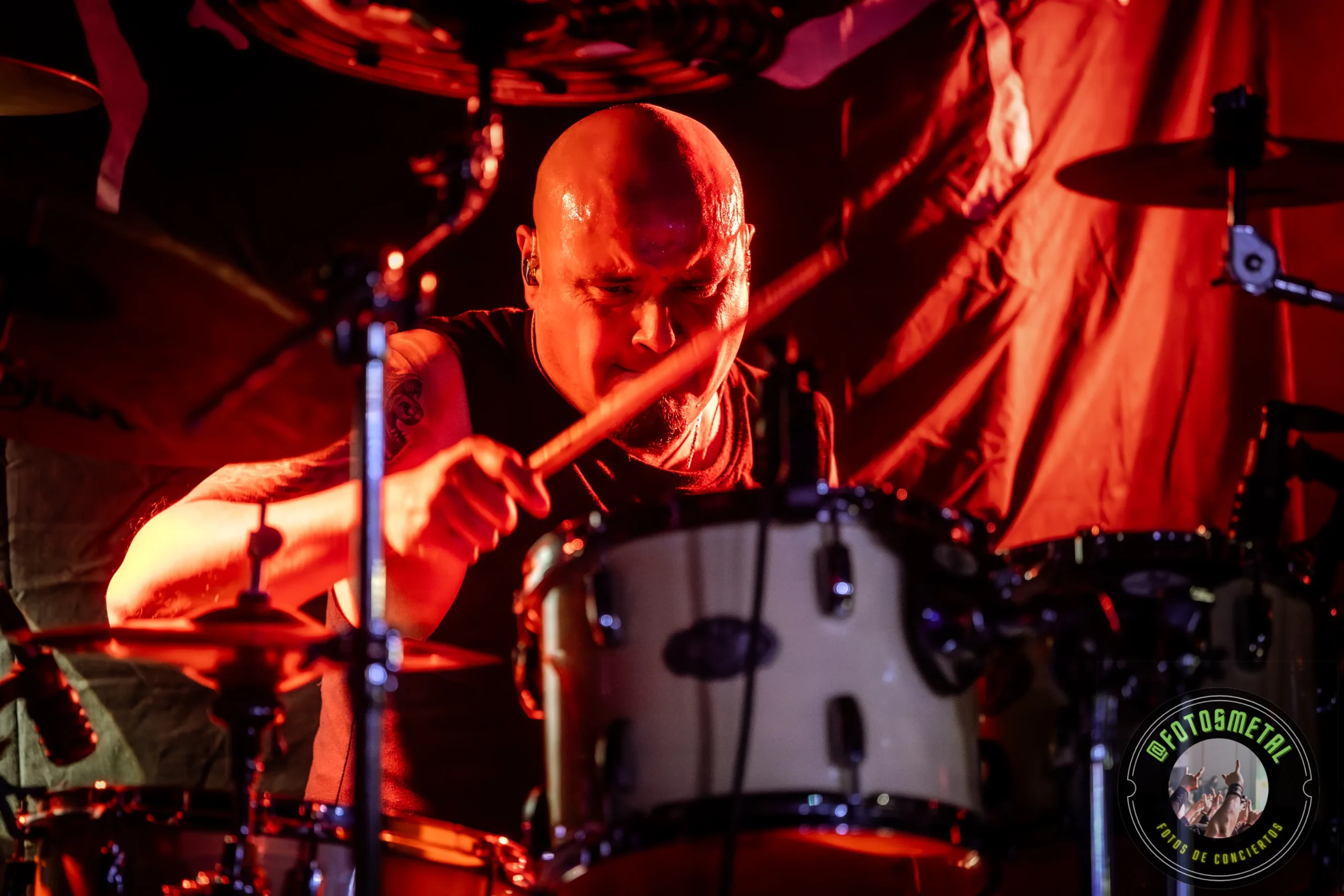 Crónica de una Ejecución Impecable: Born in Saturn y Stigmatized en RBX 6 Cantante con gafas y barba en escenario iluminado de verde apuntando y sosteniendo micrófono.