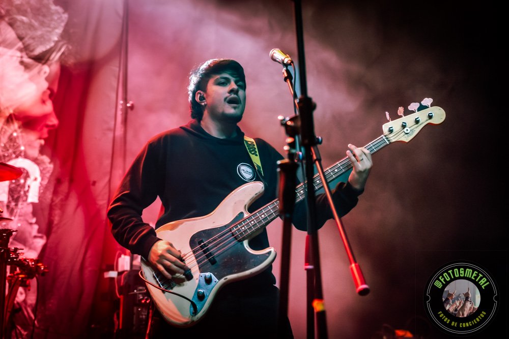 Reseña de The Haunted, Madbrain y Projector en Chile: Furia Sueca y Metal Latino 5 Cantante con gafas y barba en escenario iluminado de verde apuntando y sosteniendo micrófono.