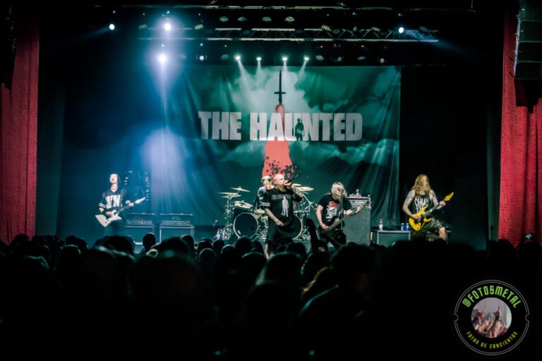 Reseña de The Haunted, Madbrain y Projector en Chile: Furia Sueca y Metal Latino 18 Banda de metal en escenario tocando ante público con telón que dice THE HAUNTED y luces azules.