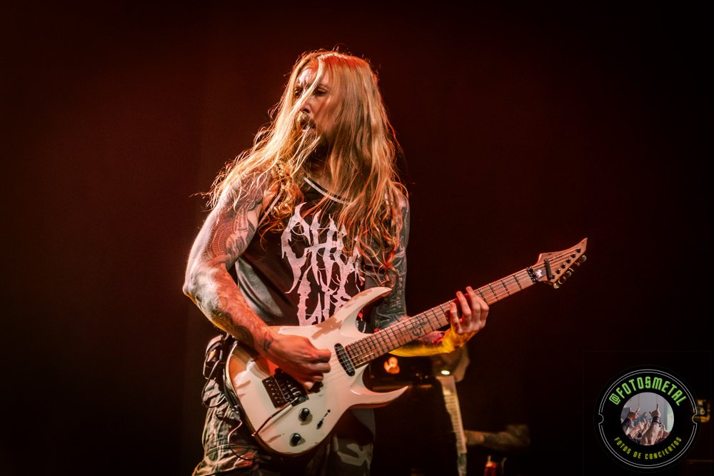 Reseña de The Haunted, Madbrain y Projector en Chile: Furia Sueca y Metal Latino 9 Cantante con gafas y barba en escenario iluminado de verde apuntando y sosteniendo micrófono.