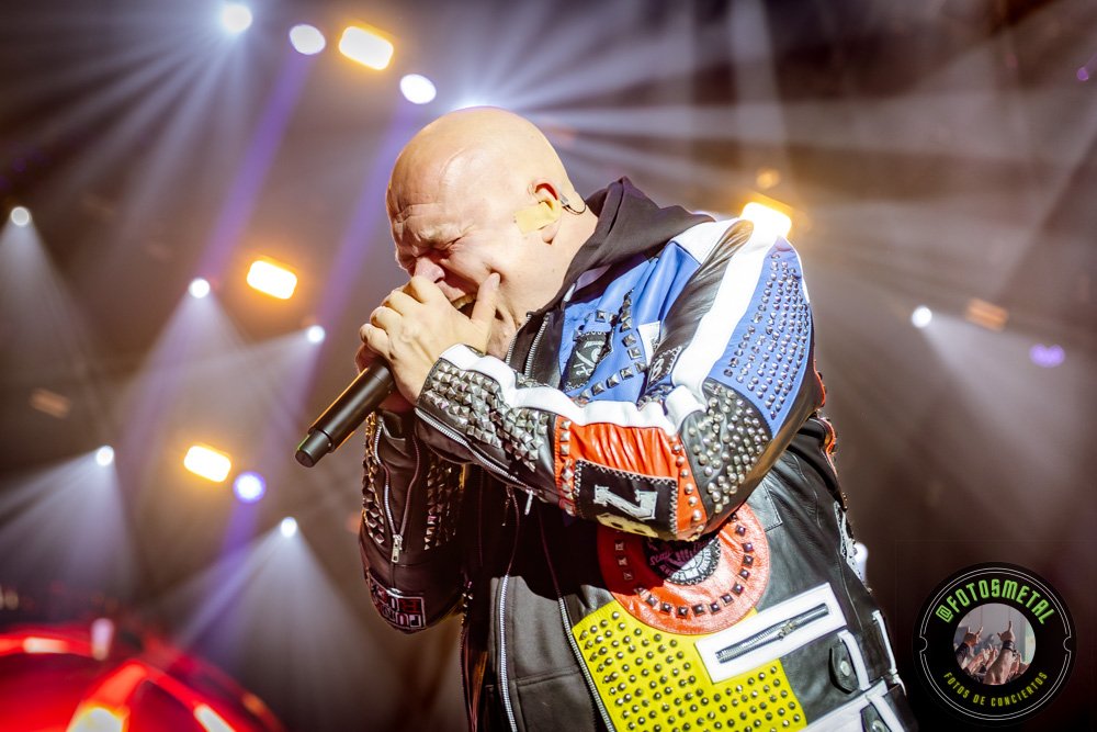 Fuego, Demonios y Luz: Helloween 2026 5 Cantante con gafas y barba en escenario iluminado de verde apuntando y sosteniendo micrófono.
