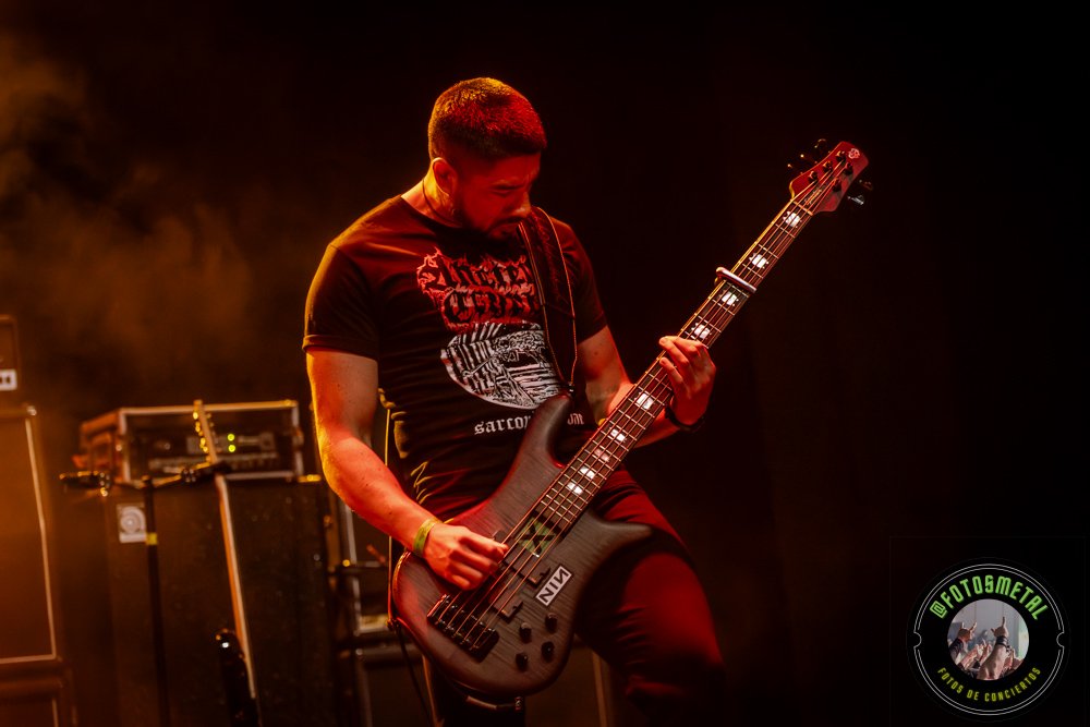 Left to Die en Chile: El eco primitivo del death metal choca en el Teatro Cariola 2 Cantante con gafas y barba en escenario iluminado de verde apuntando y sosteniendo micrófono.