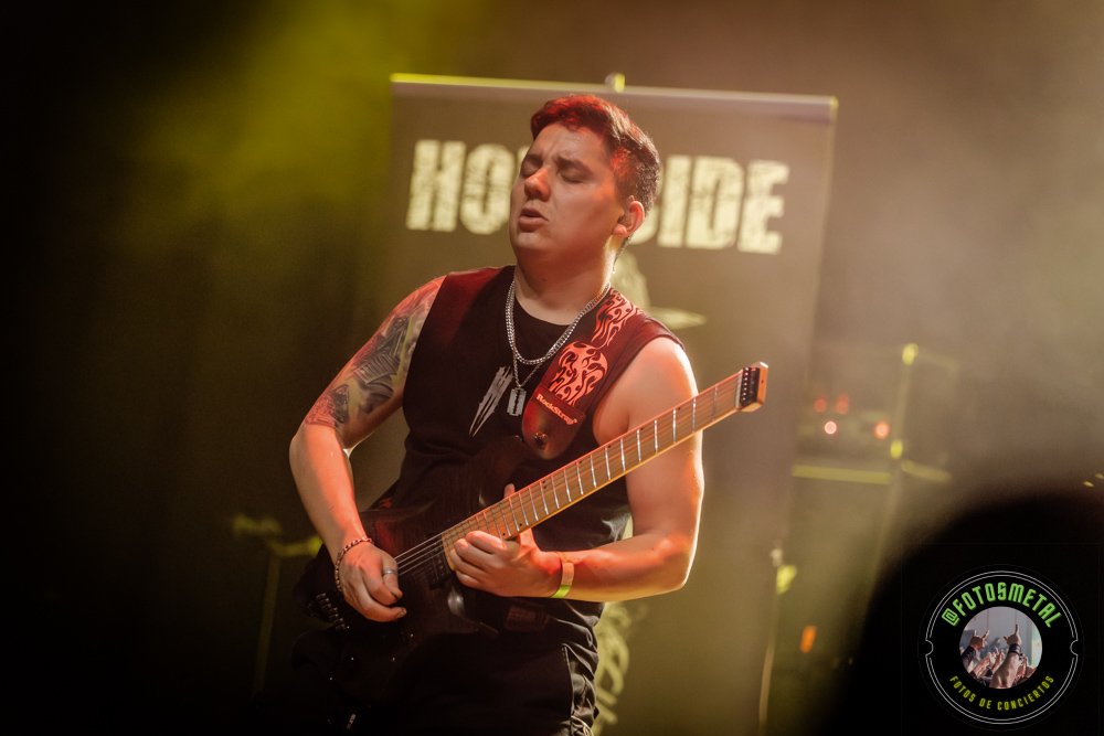 Left to Die en Chile: El eco primitivo del death metal choca en el Teatro Cariola 5 Cantante con gafas y barba en escenario iluminado de verde apuntando y sosteniendo micrófono.