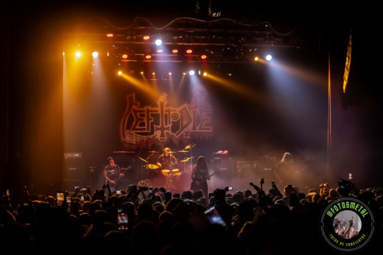 Left to Die en Chile: El eco primitivo del death metal choca en el Teatro Cariola 17 Concierto en un escenario con cuatro músicos tocando bajo luces amarillas y azules, público con celulares al frente.