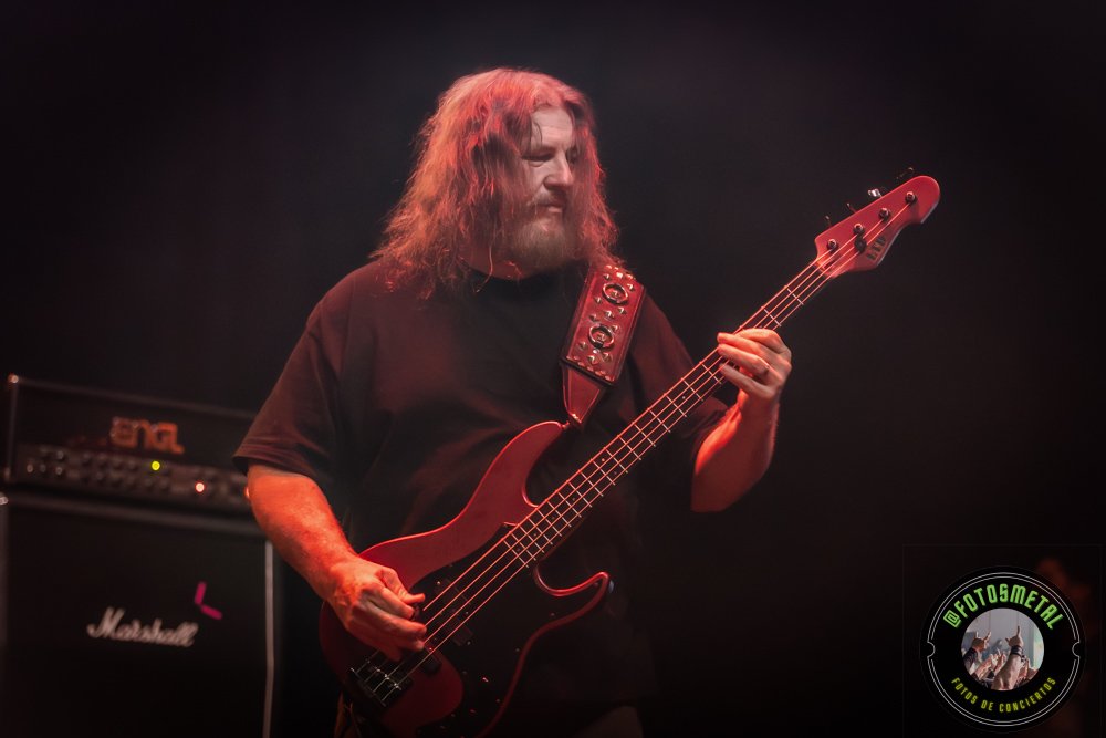 Left to Die en Chile: El eco primitivo del death metal choca en el Teatro Cariola 13 Cantante con gafas y barba en escenario iluminado de verde apuntando y sosteniendo micrófono.