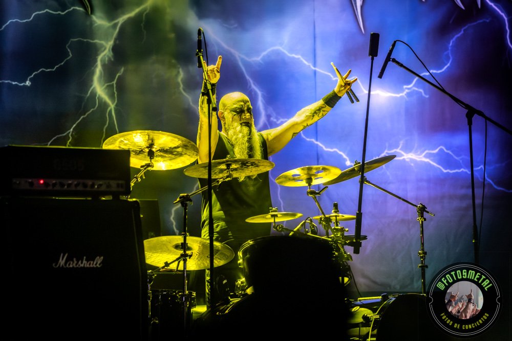Old Man’s Child en Chile 2026: Reseña y Setlist en el Cariola 9 Cantante con gafas y barba en escenario iluminado de verde apuntando y sosteniendo micrófono.