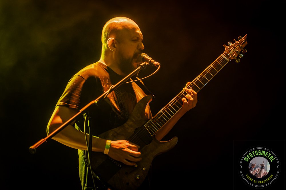 Old Man’s Child en Chile 2026: Reseña y Setlist en el Cariola 2 Cantante con gafas y barba en escenario iluminado de verde apuntando y sosteniendo micrófono.