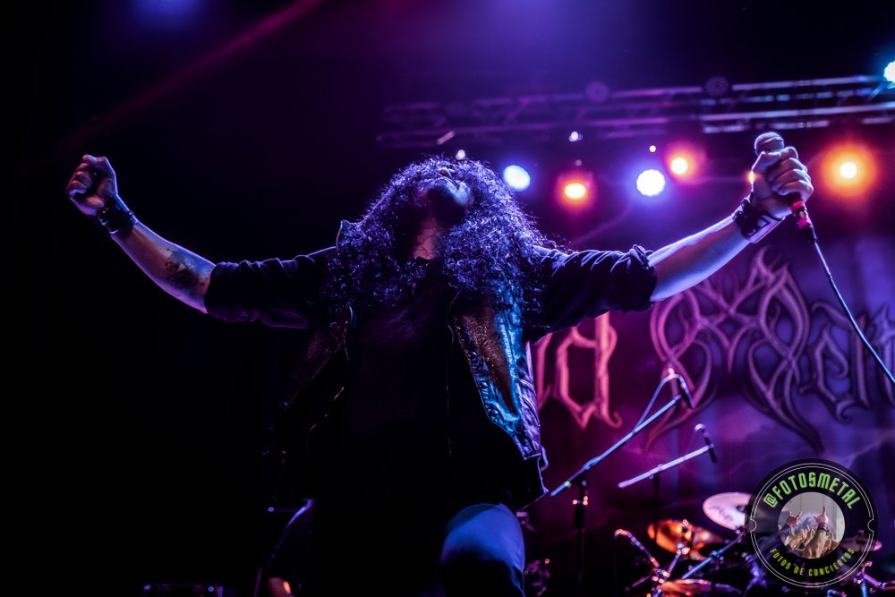 Old Man’s Child en Chile 2026: Reseña y Setlist en el Cariola 1 Cantante de cabello largo levanta brazos en escenario con micrófono y banda.